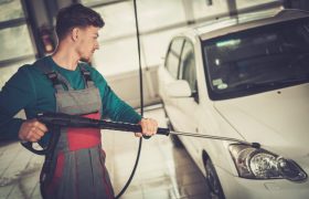 Man worker washing car on a car wash